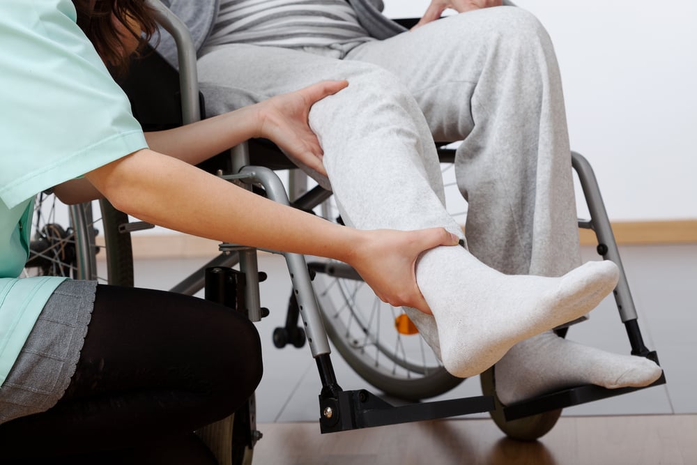 Young physiotherapist exercising with elder disabled person-2